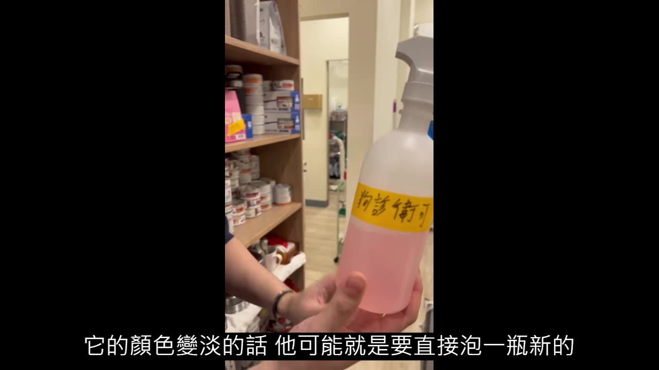 手拿一瓶粉紅色液體的噴瓶，黃色膠帶標籤手寫「狗診 衛可」