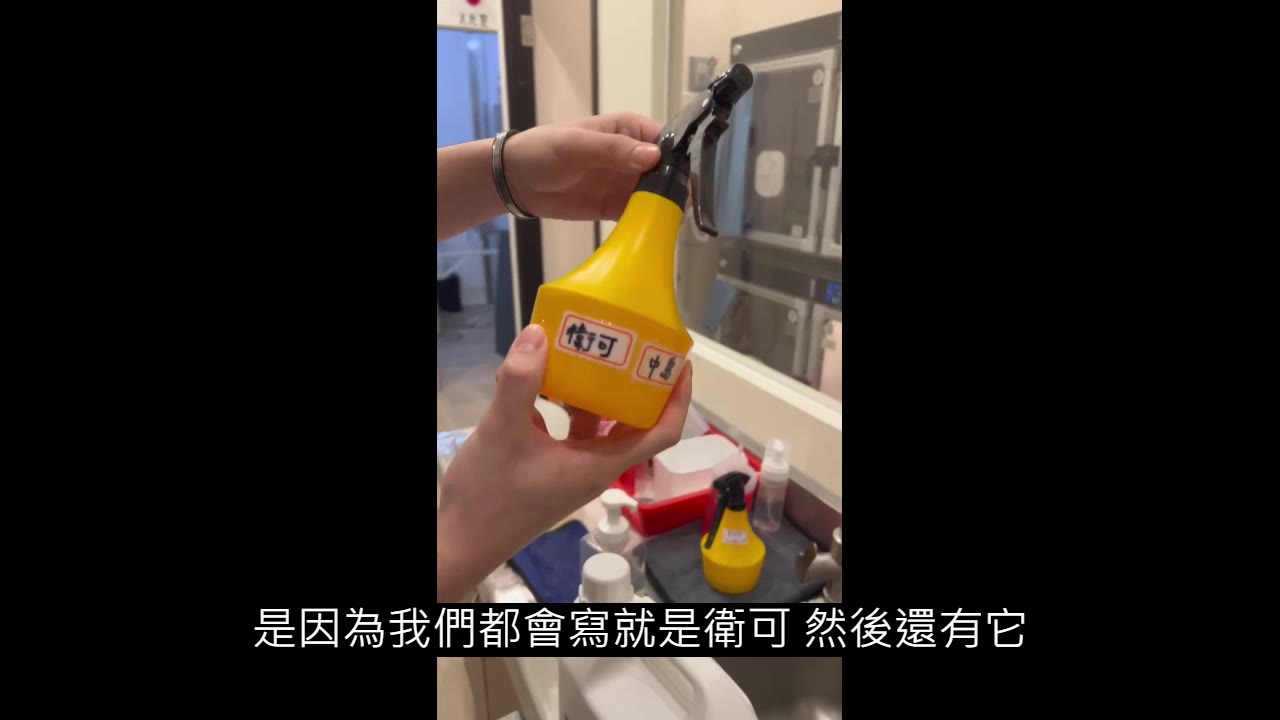 手拿黃色噴瓶，瓶身貼著「衛可」與另一張標示位置的標籤